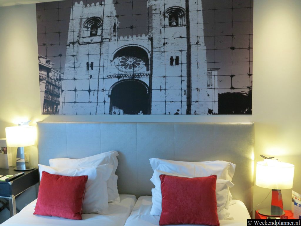 Op deze hotelkamer zie je aan de muur een grote afbeelding van de kathedraal in Alfama, Sé de Lisboa.Tip: Reserveer een kamer in dit hotel.